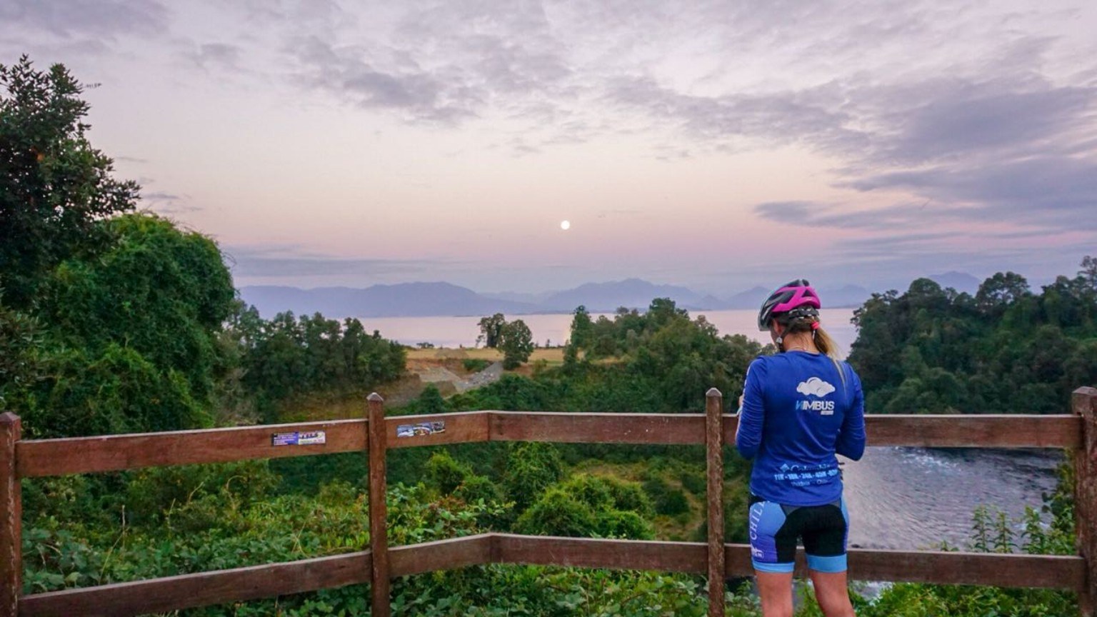 Ciclista contemplando el lago al atardecer